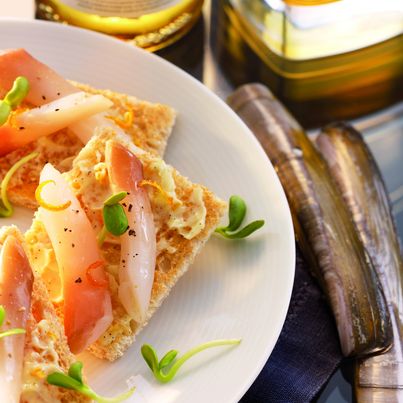 Un toast de pain de mie aux céréales, du beurre à la vanille et aux zestes d'orange, un morceau de couteau et de la fleur de sel