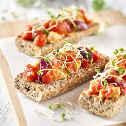 Bruschettas aux céréales, œufs brouillés crémeux et tomates pelées bio