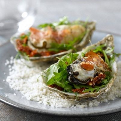 Huîtres gratinées au Parmesan sur lit de roquette, jambon de pays et tomates séchées